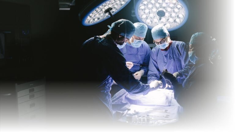 Equipe médica realizando procedimento cirúrgico sob luz intensa em uma sala de cirurgia.